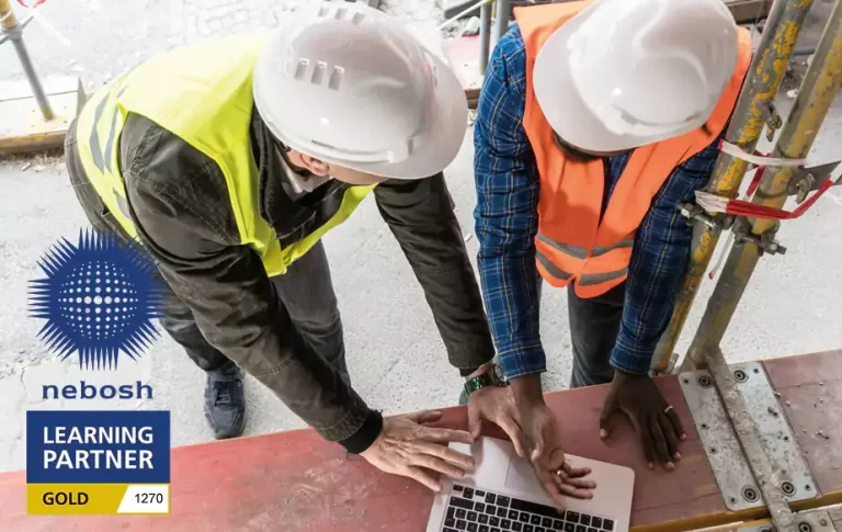 Two Construction workers completing a NEBOSH course on their laptop