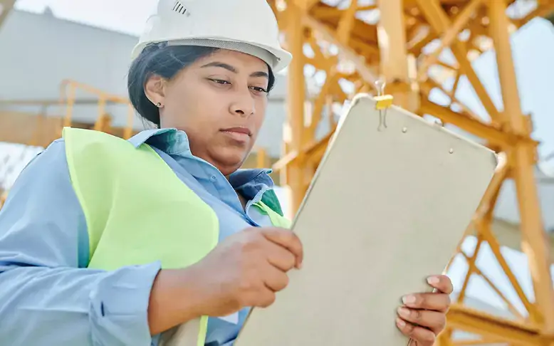 Woman completing Health and Safety Checks for a safe construction site