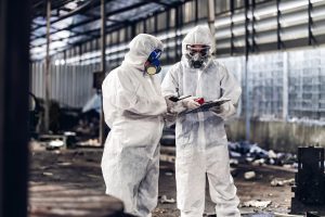 workers wearing protective hazmat suits to prevent asbestos exposure